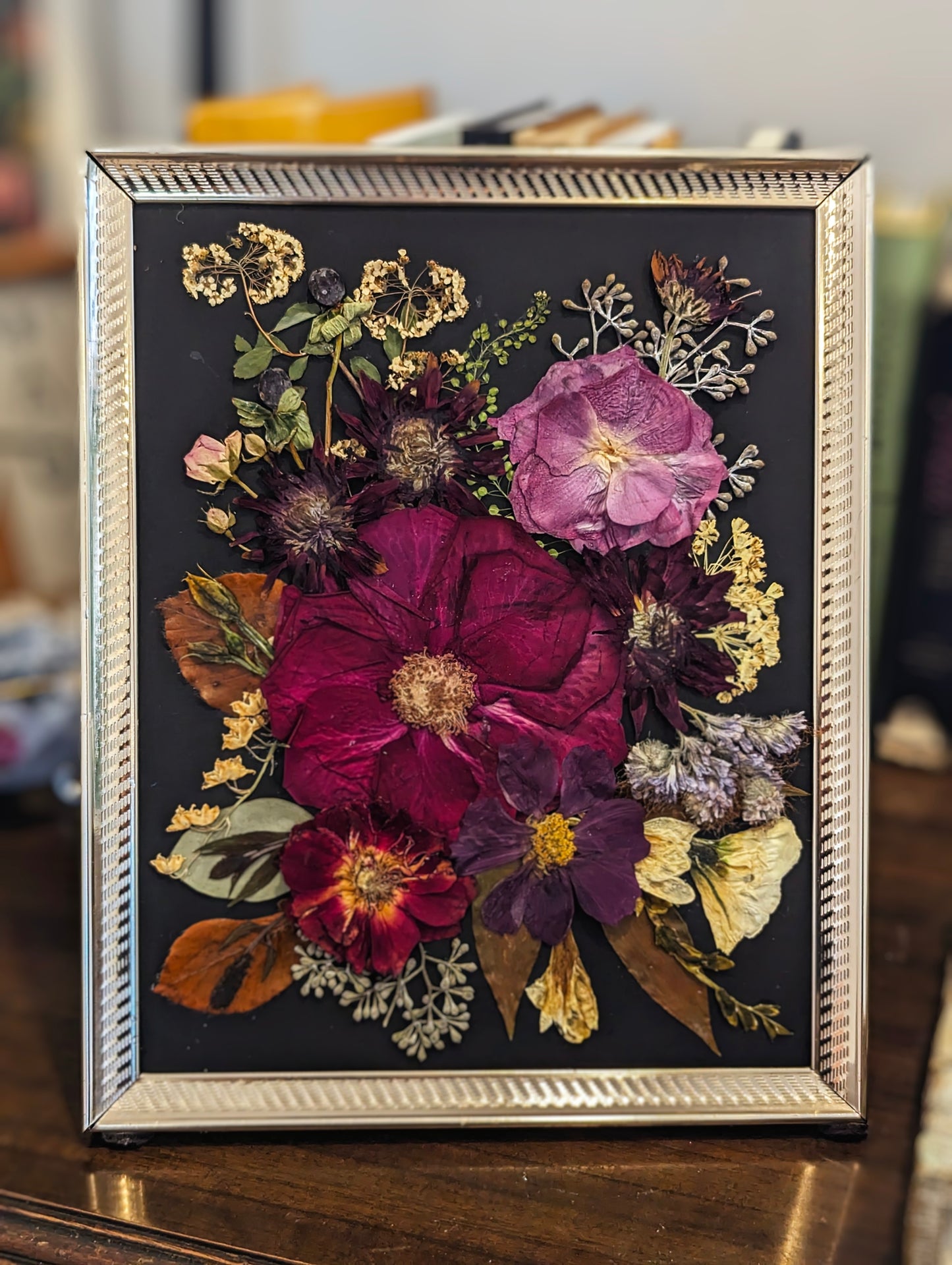 Floral art piece showcasing pressed sunflowers arranged in a vintage frame.