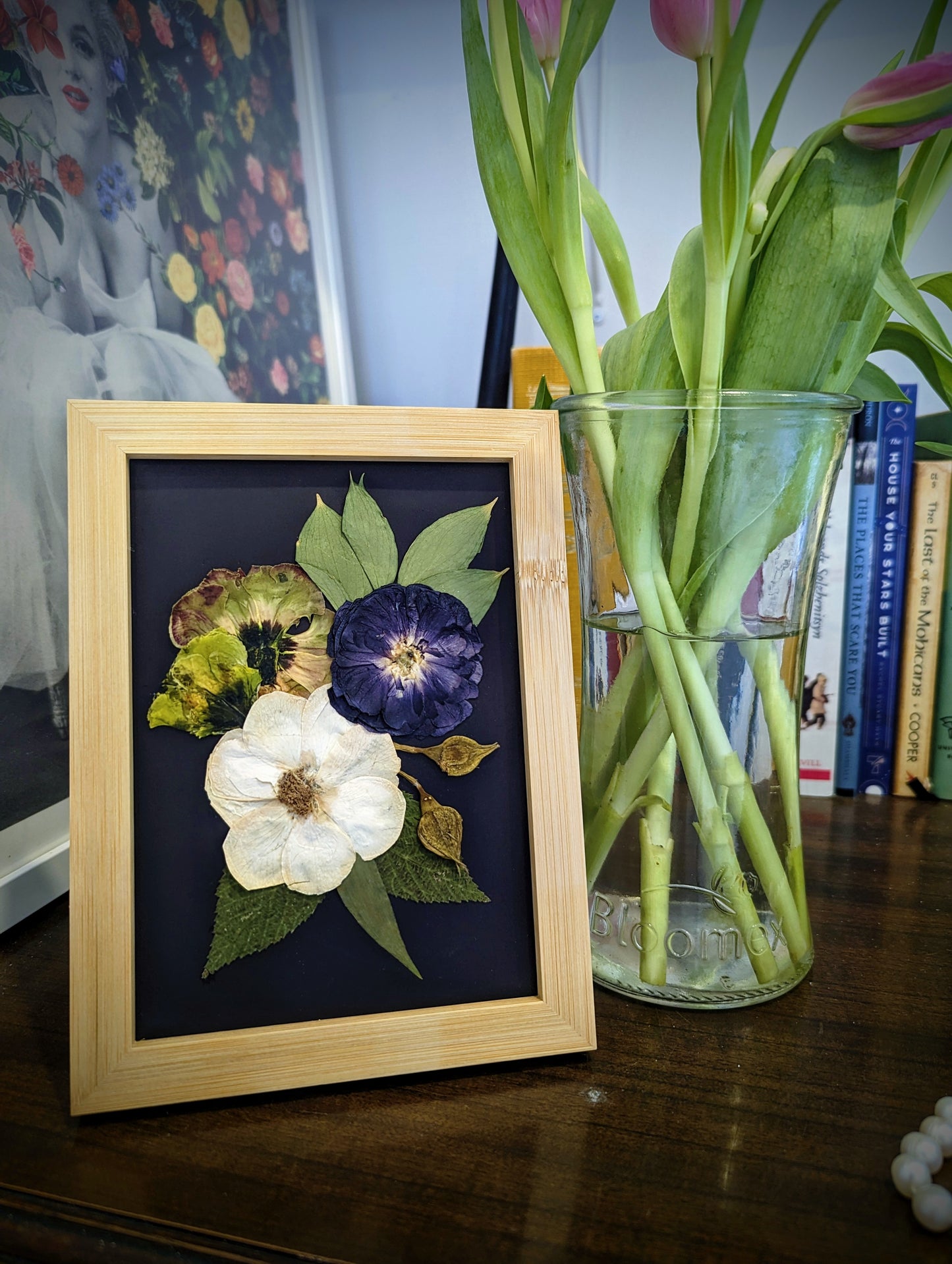 Handmade pressed flower artwork with a vintage aesthetic in a gold frame.