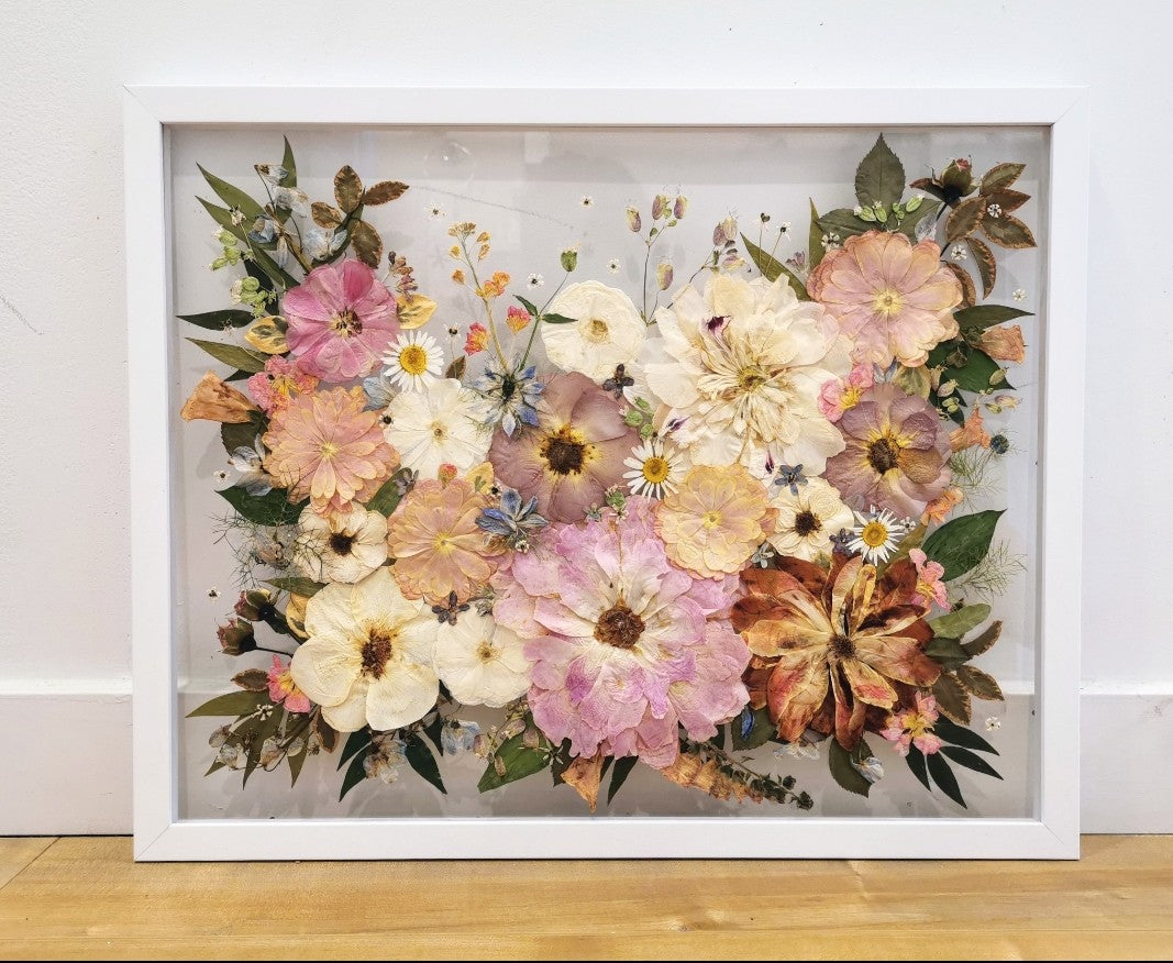 Unique art piece combining various pressed flowers and herbs in an abstract design.