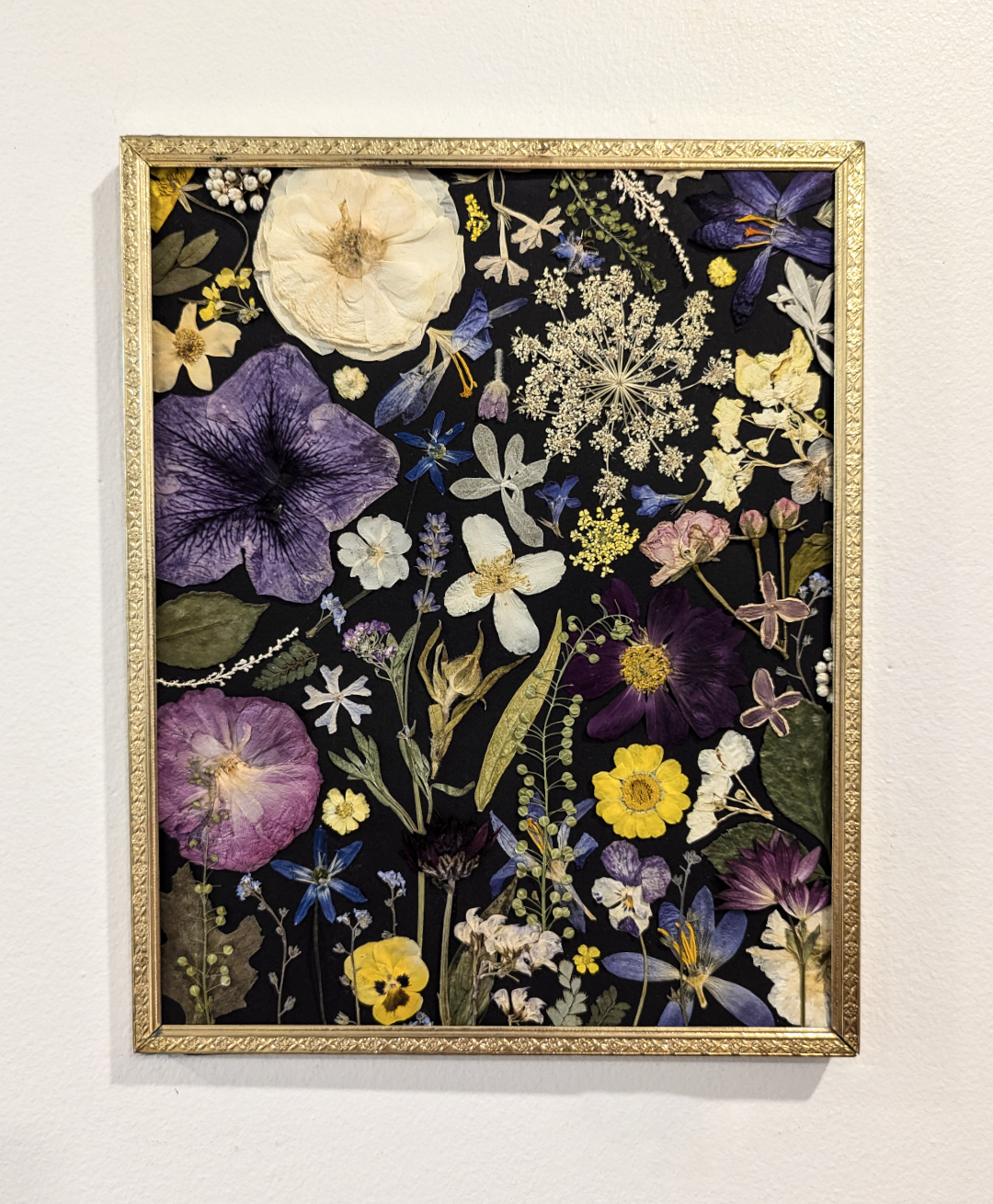 Nature-inspired artwork featuring pressed fern leaves and blossoms.