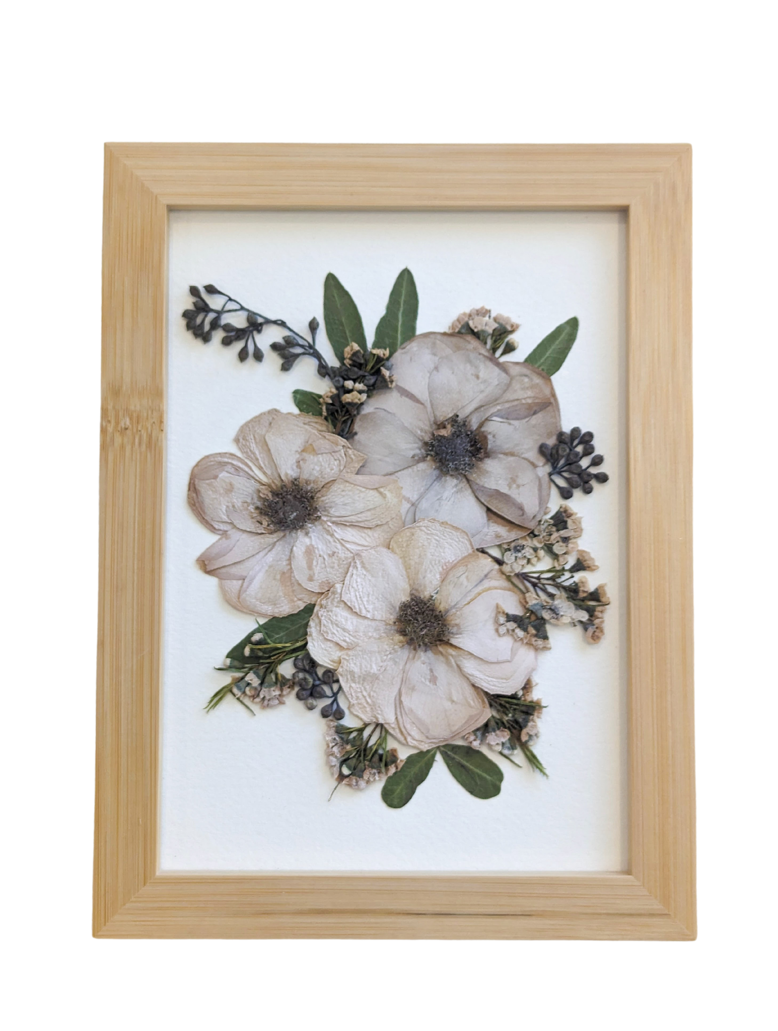Handmade pressed flower artwork with a vintage aesthetic in a gold frame.