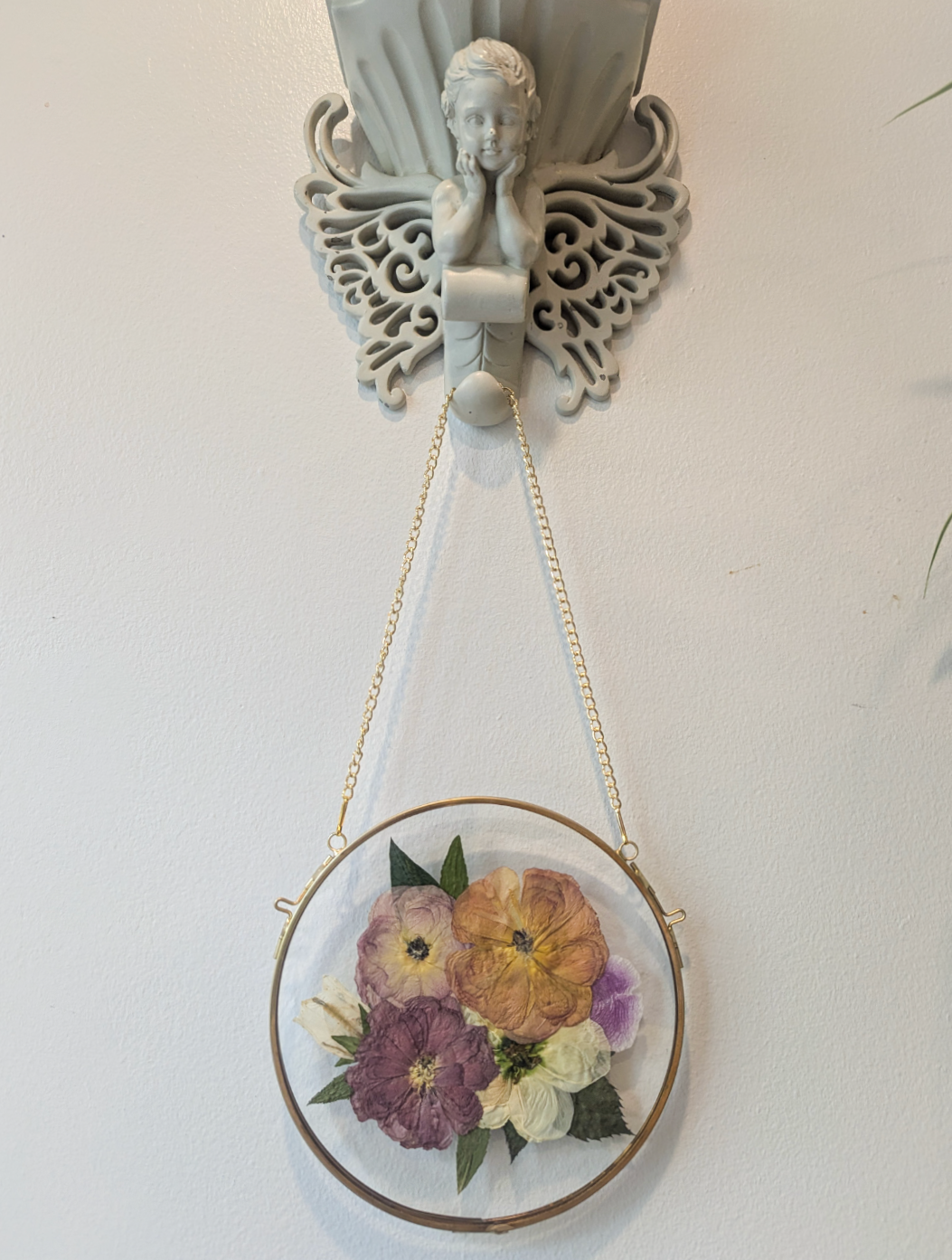 Pressed flower arrangement displayed as a centerpiece in a glass frame.