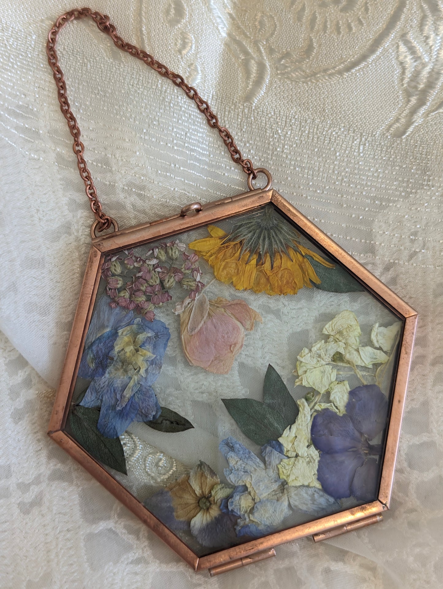 Handcrafted wedding keepsake featuring pressed flowers in a vintage frame.